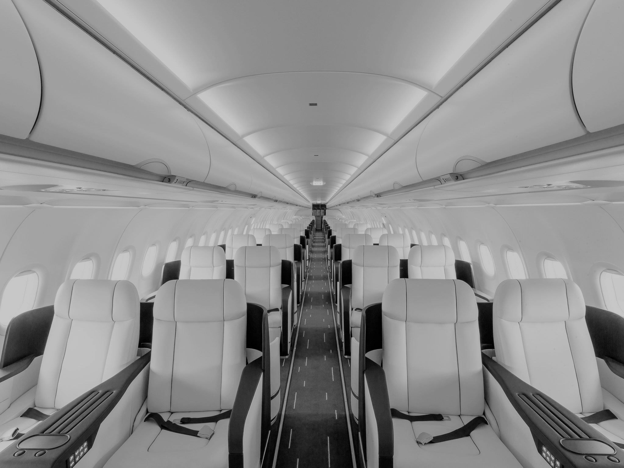 The cabin of a charter airliner fitted with rows of wide leather seats