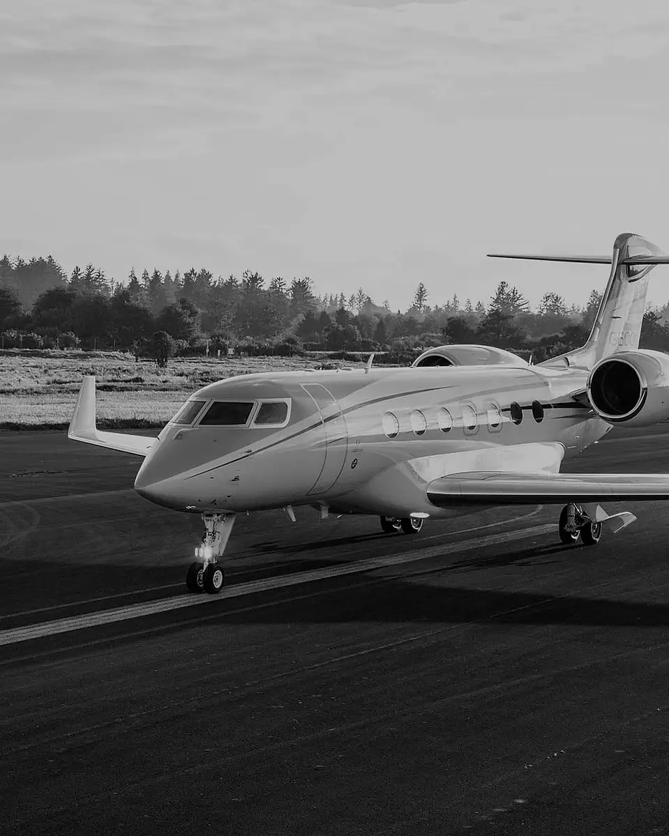 A long-range private jet on a runway in early morning light
