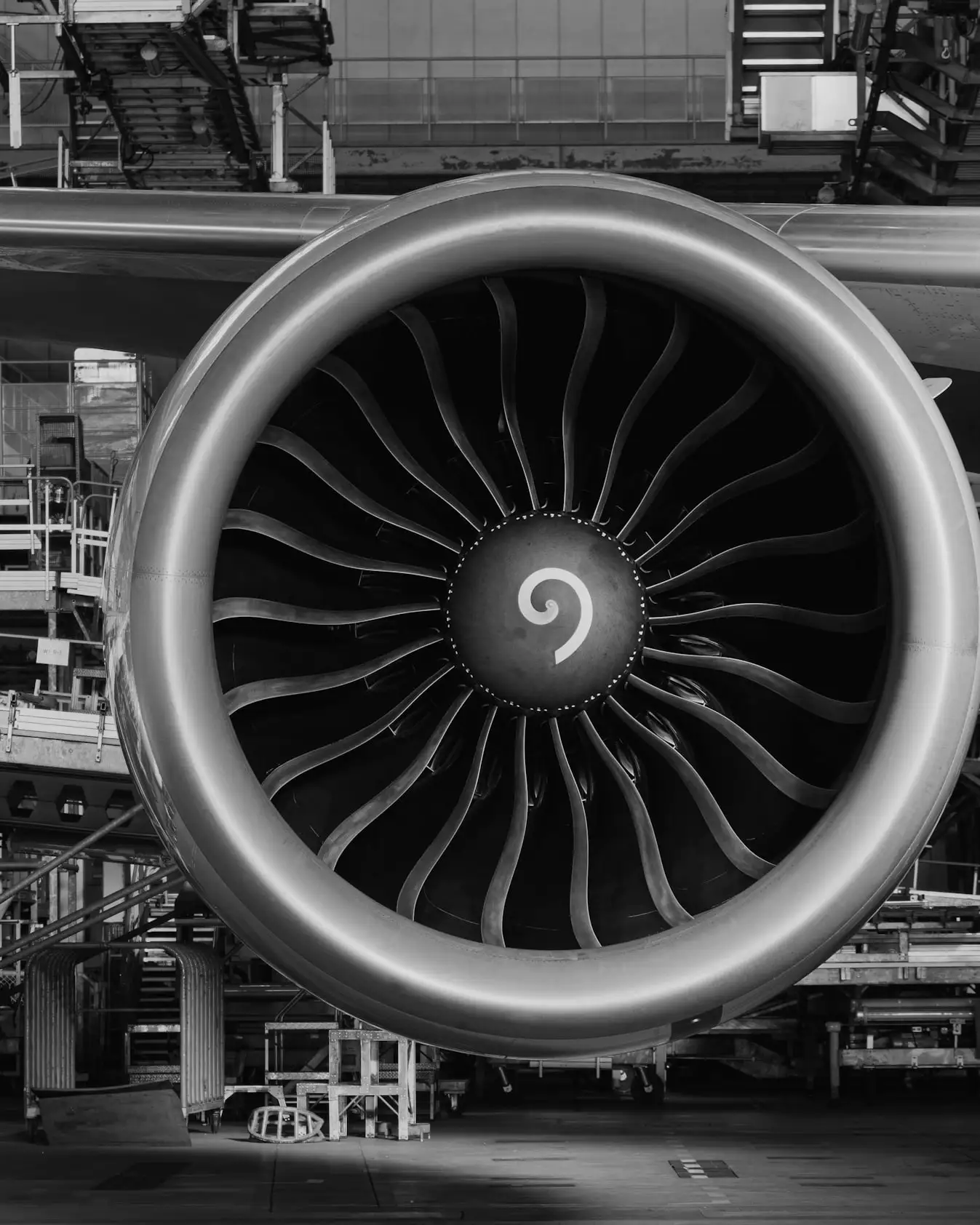 A jet engine on the wing in a maintenance hangar