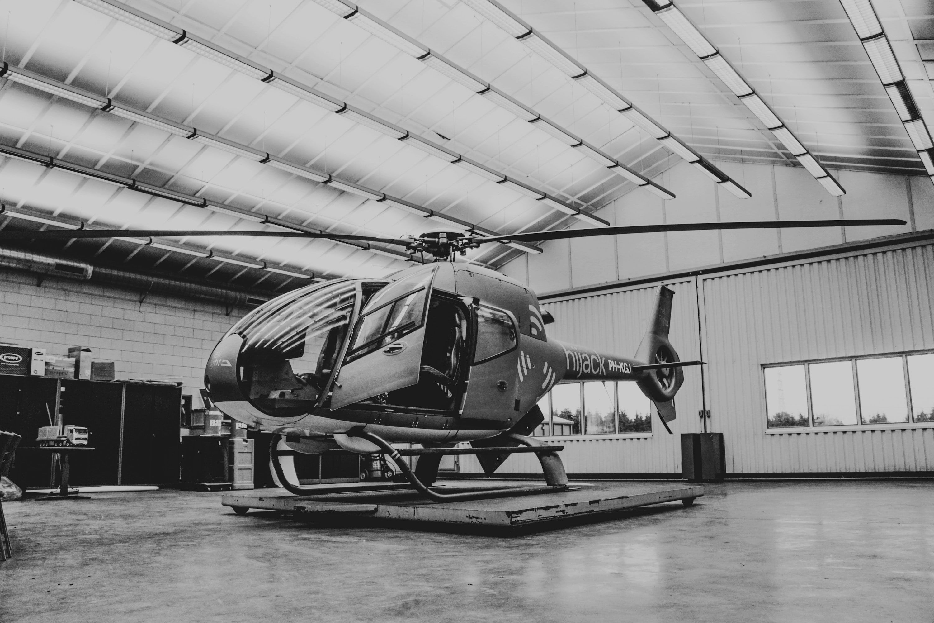 A helicopter on a maintenance platform inside a hangar