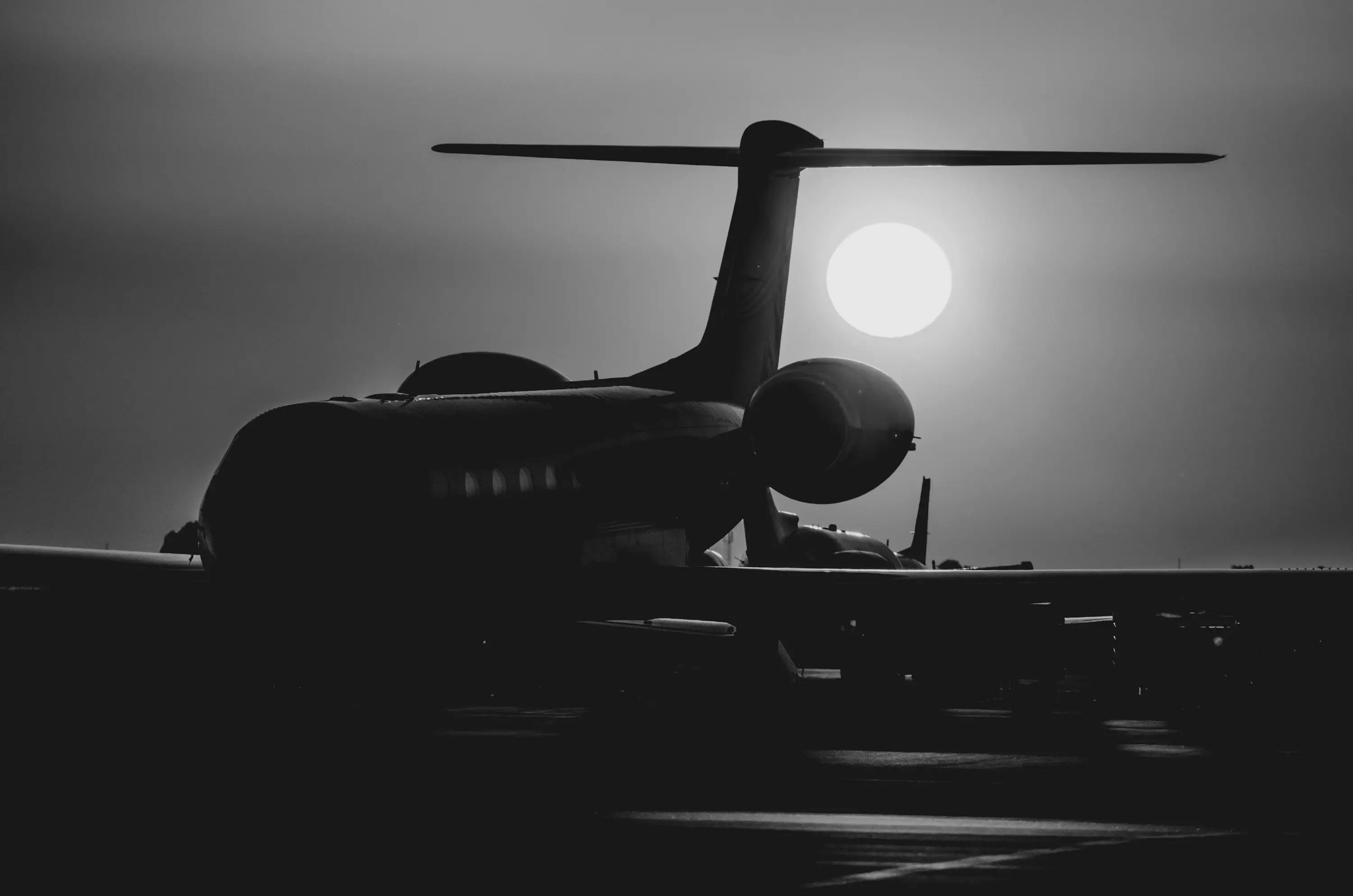 A business jet in silhouette against a low sun